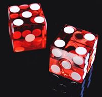 Two translucent red casino dice with sharp edges and white pips