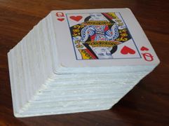Leaning stack of playing cards forming an oblique prism