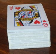 Vertical stack of playing cards forming a right prism