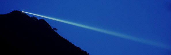 Single beam of light shining through a small opening in a dark room